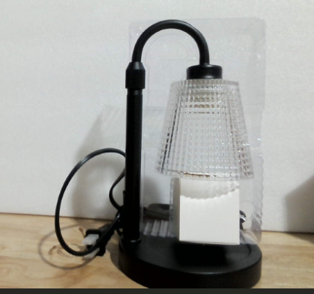 La lámpara de la imagen es la variante física desempacada de la Lámpara Calentadora de Velas Eléctrica con Pantalla de Cristal y Base de Metal Negro Mate.
