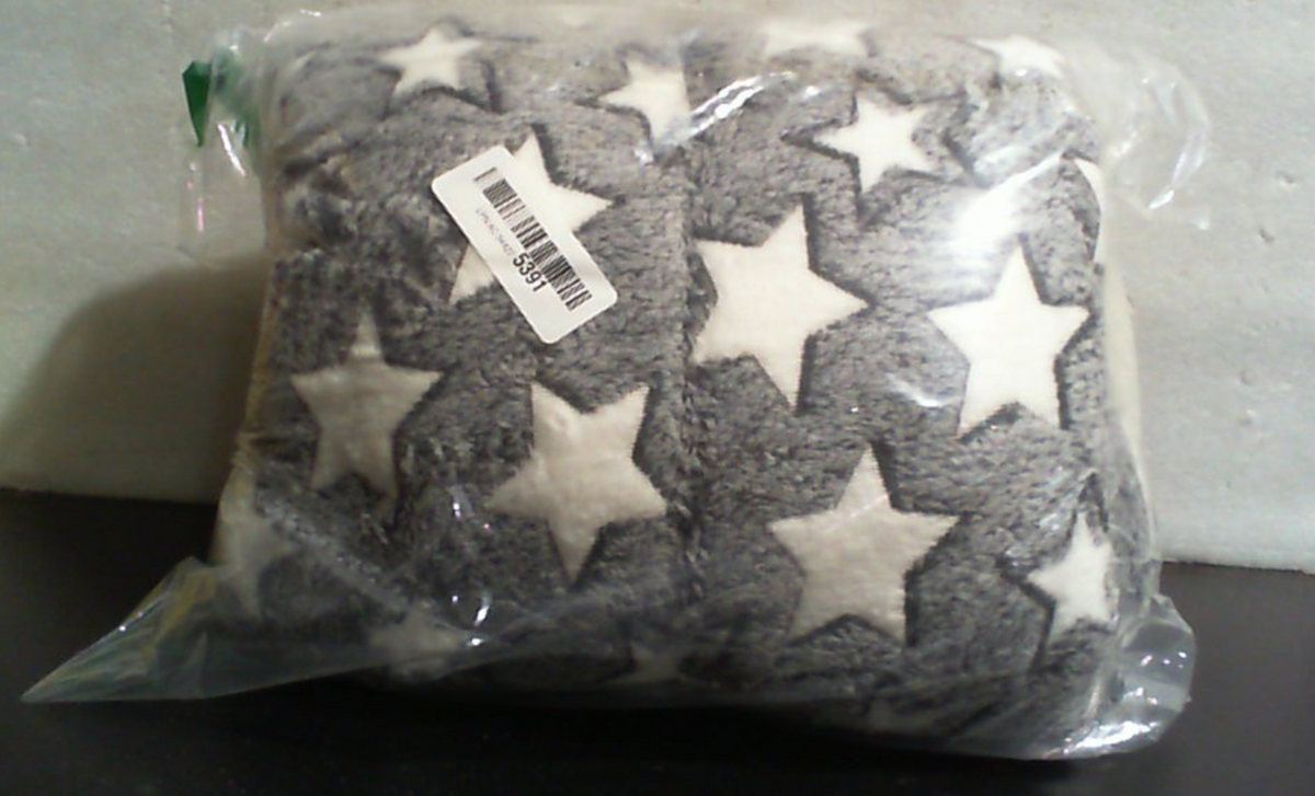 Manta gris de textura afelpada con estrellas blancas para un hogar acogedor
