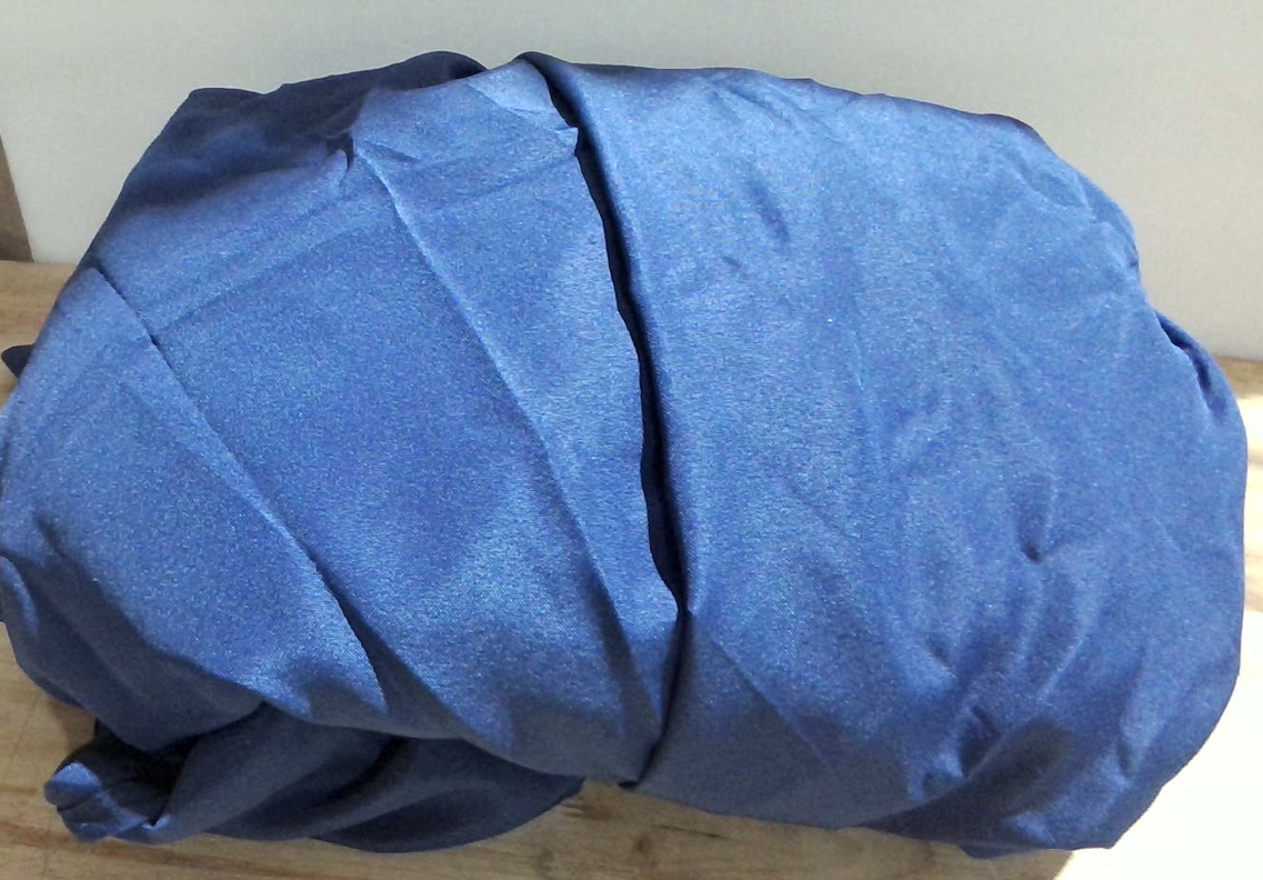 mantel azul marino doblado, confeccionado en una tela sintética lisa con un ligero brillo satinado (típicamente poliéster o satén( ARTICULO VIENE COMO SE MUESTRA EN LA IMAGEN 2