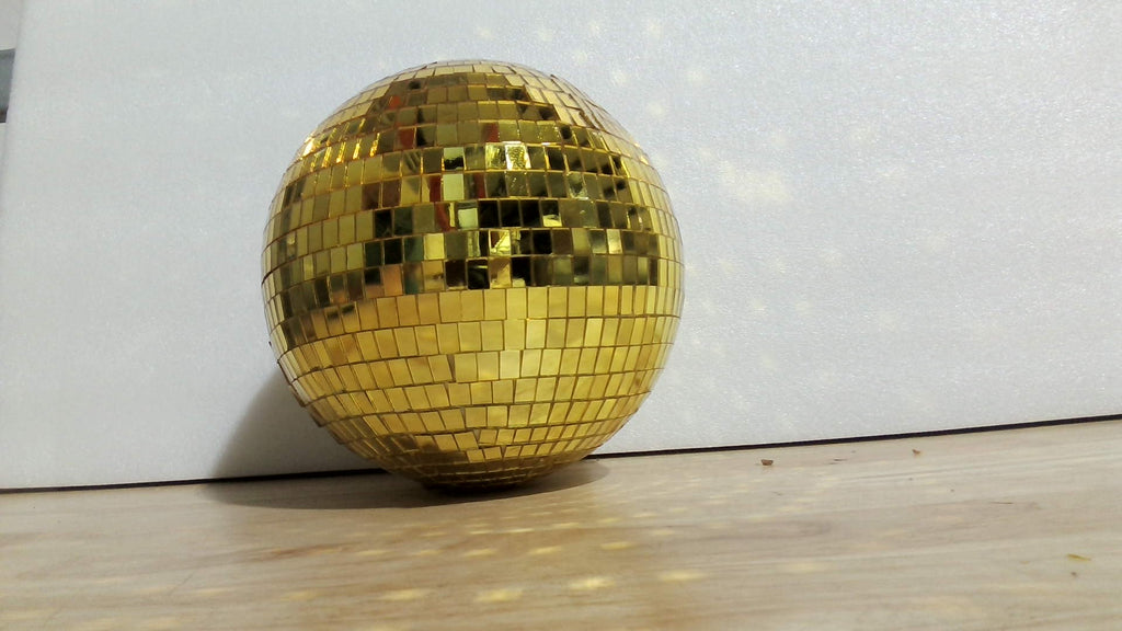 Bola de discoteca dorada con facetas espejadas