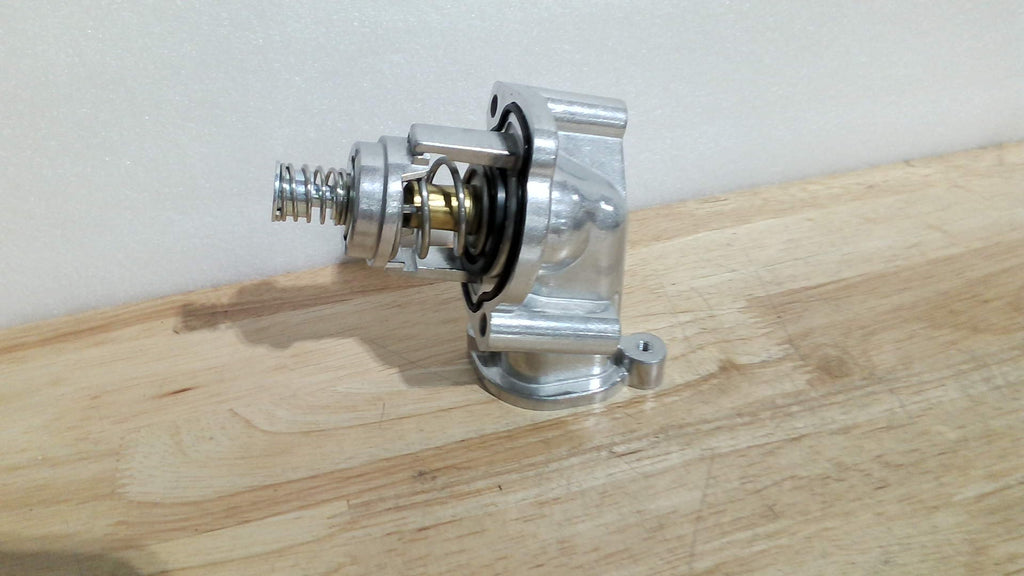 termostato automotriz completo con su toma de agua o carcasa metálica de aluminio (Engine Coolant Thermostat Housing Assembly).