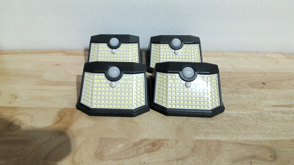 HMCITY Luces Solares de Exterior 120 LED | 3 Modos de Iluminacion con Sensor de Movimiento | Impermeable IP65 | Luces Solares de Pared para Jardin y Deck | 4 Piezas, Botón Frontal, Carcasa Negra, Luz Blanca
