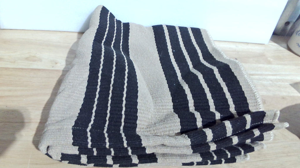 alfombra tejida de algodón o lana con un patrón de rayas negras sobre un fondo caqui, beige o natural ( DISENO IGUAL A LA SEGUNAD IMAGEN )