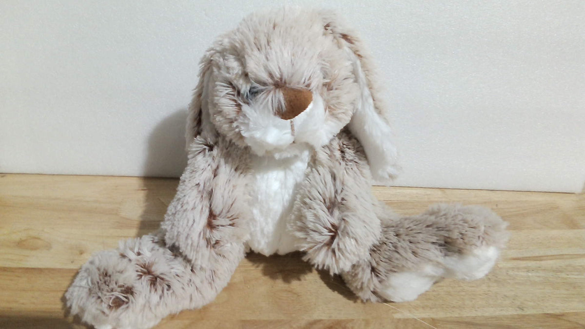 Burrow Bunny de Melissa & Doug (Conejo de Madriguera), un peluche sumamente popular reconocido por sus orejas largas caídas, patas grandes y pelaje extrasuave en tonos beige y blanco ( ARTICULO VIENE COMO SE OBSERVA EN LA SEGUNDA IMAGEN )