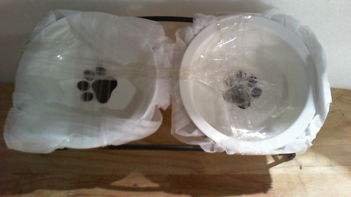 comedero doble elevado para mascotas con platos de cerámica blanca y sosten de varilla negra.
