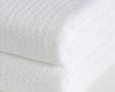 pila de toallas blancas dobladas y organizadas por tamaño sobre una superficie de madera.ARTICULO VIENE COMO SE MUESTRA EN LA SEGUNDA IMAGEN ( CONTIENE 5 PIEZAS )