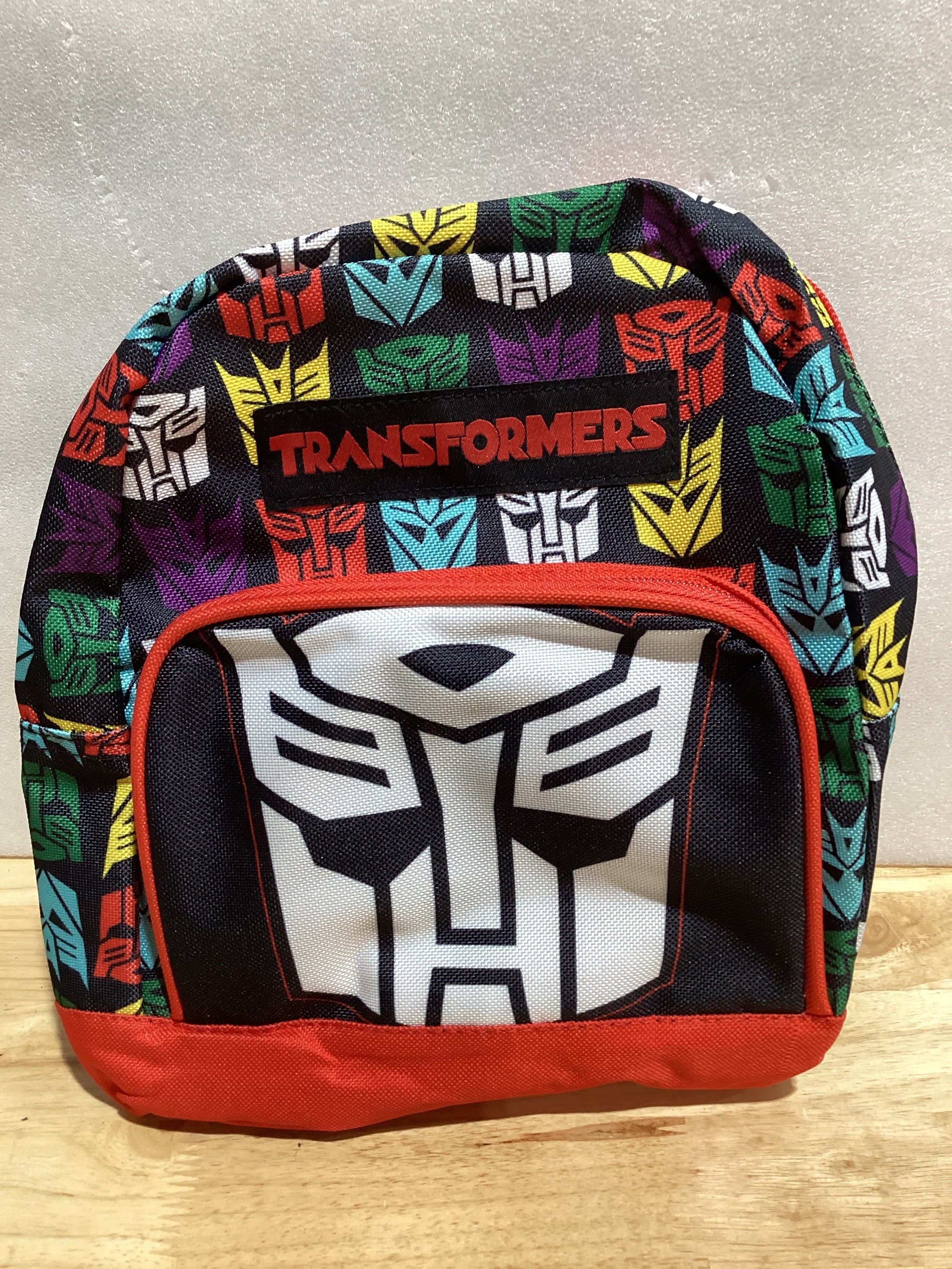Transformers Mini mochila – Mochila pequeña tejida exclusiva de 10 pulgadas con bolsillo frontal y paquete de botones | Se ajusta para adaptarse a adultos, adolescentes, niños